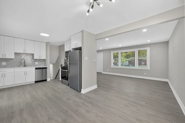 a kitchen with stainless steel appliances a refrigerator sink and cabinets