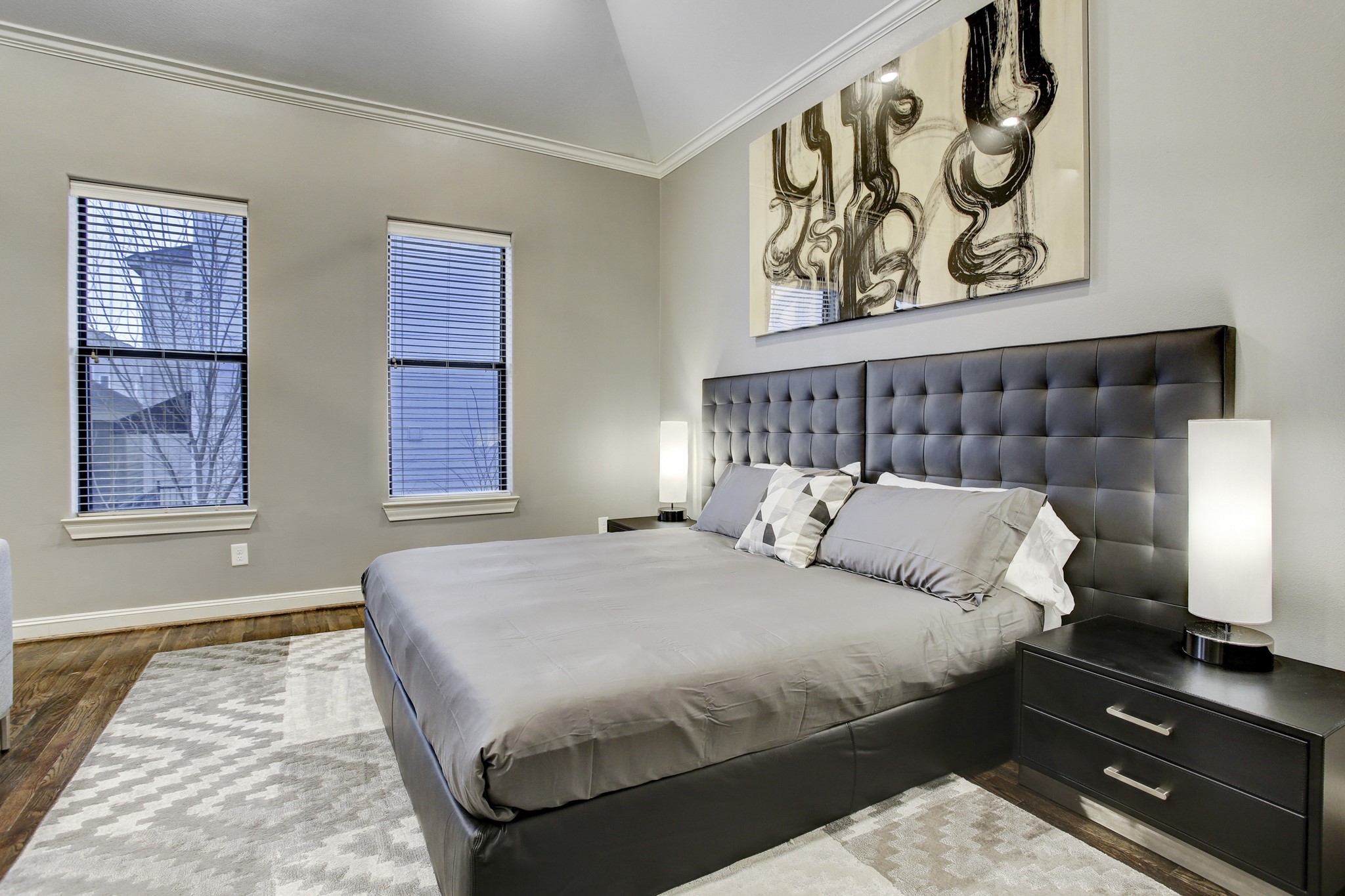 5506 Darling Street Houston, TX 77007 - Photo 10 of 23 Elegant Primary Bedroom with cathedral ceiling, ensuite bath and walk-in closet. Notice the king-sized bed & night stands, and sophisticated neutral palette of furnishings.