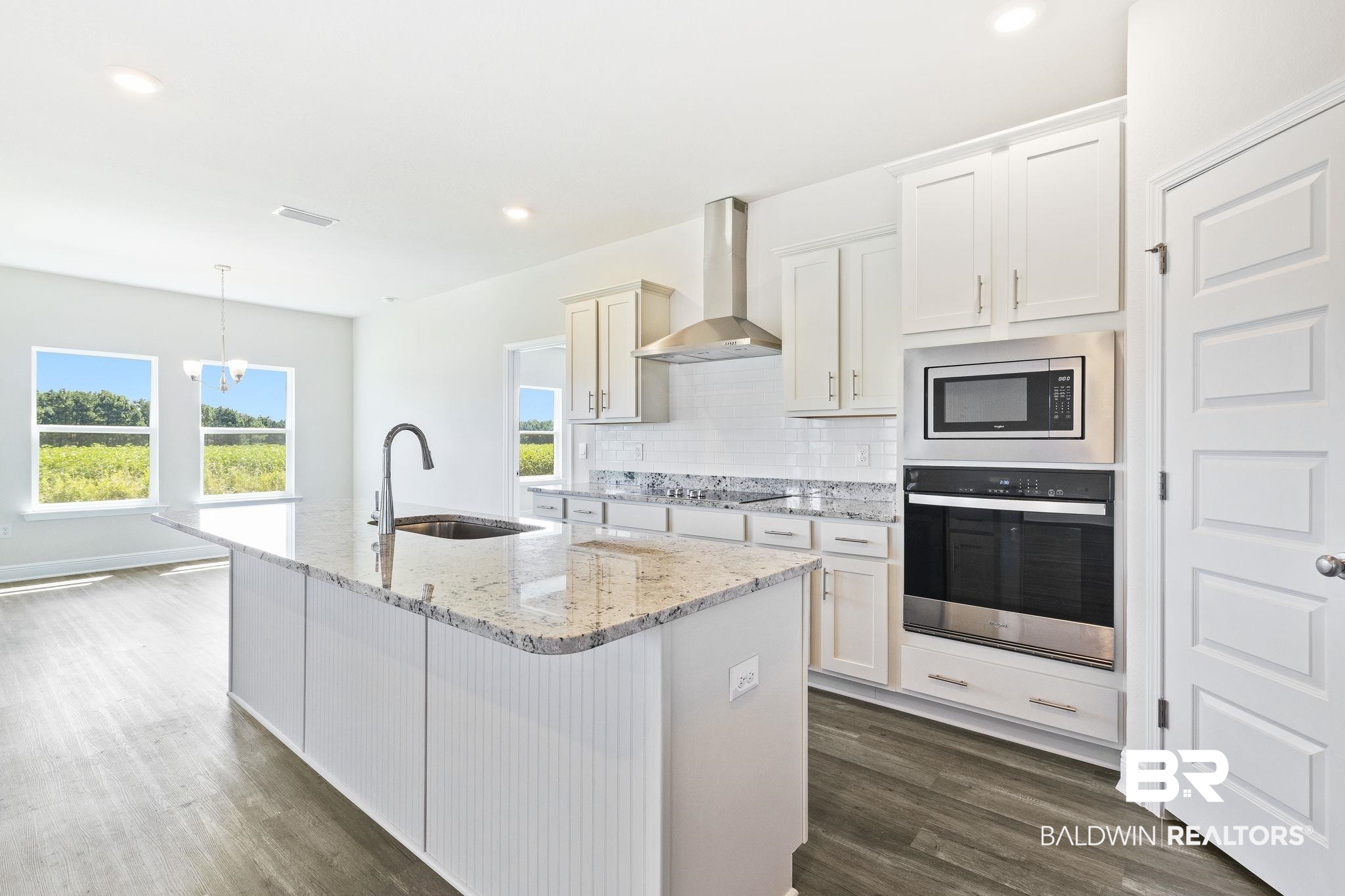 11303 Genuine Risk Circle Daphne, AL 36526 - Photo 23 of 100 Kitchen with sink, dark hardwood / wood-style flooring, appliances with stainless steel finishes, wall chimney exhaust hood, and tasteful backsplash