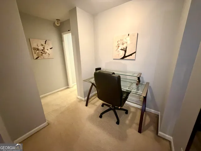 a view of a workspace with furniture and a window
