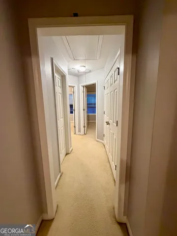 a view of a hallway with wooden shelves