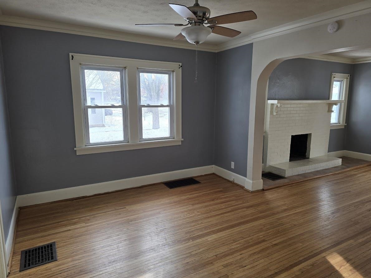 2103 North Court Street Rockford, IL 61103 - Photo 5 of 14 a view of an empty room with wooden floor fireplace and a window