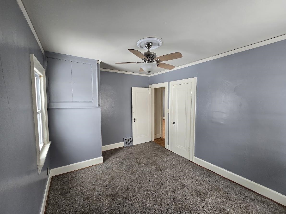 2103 North Court Street Rockford, IL 61103 - Photo 8 of 14 an empty room with a ceiling fan and a window