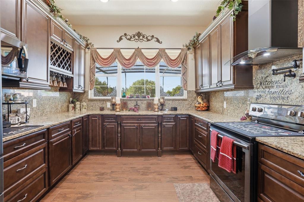 13429 Montevista Road Clermont, FL 34711 - Photo 19 of 89 a kitchen with stainless steel appliances granite countertop a stove and cabinets