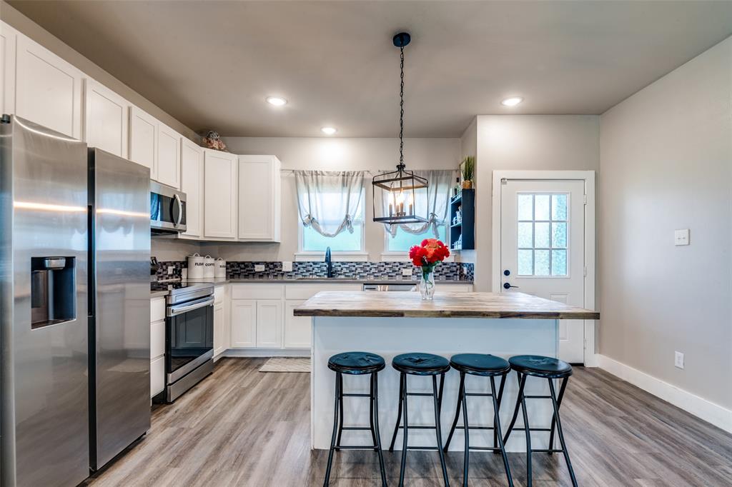 1205 Edgar Street Greenville, TX 75401 - Photo 14 of 26 a kitchen with granite countertop white cabinets and stainless steel appliances