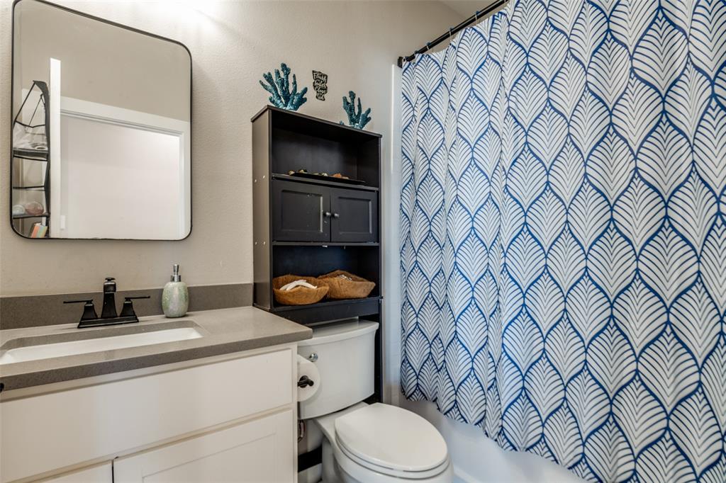 1205 Edgar Street Greenville, TX 75401 - Photo 19 of 26 a bathroom with a granite countertop toilet sink and mirror