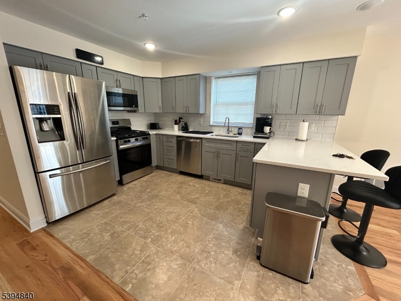 337 13th Avenue, Unit 1 Newark, NJ 07103 - Photo 4 of 14 a kitchen with stainless steel appliances a refrigerator stove microwave and sink