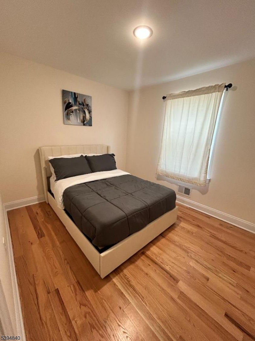 337 13th Avenue, Unit 1 Newark, NJ 07103 - Photo 7 of 14 a bedroom with a bed and painting on the wall