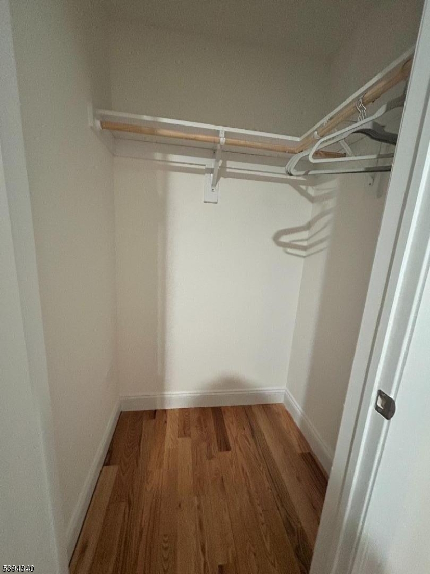 337 13th Avenue, Unit 1 Newark, NJ 07103 - Photo 8 of 14 a view of a room with wooden floor and small racks