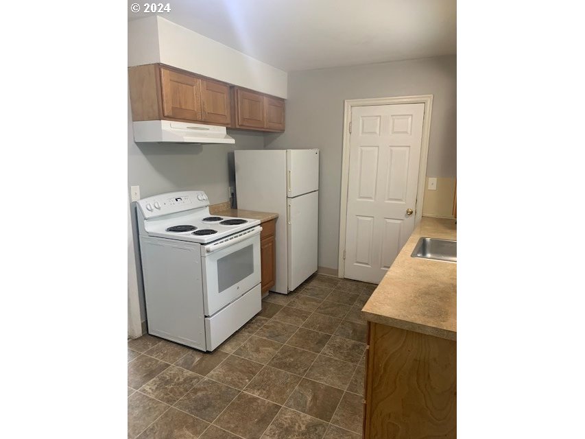 8445 Southeast Washington Street Portland, OR 97216 - Photo 11 of 17 a kitchen with a stove and a refrigerator