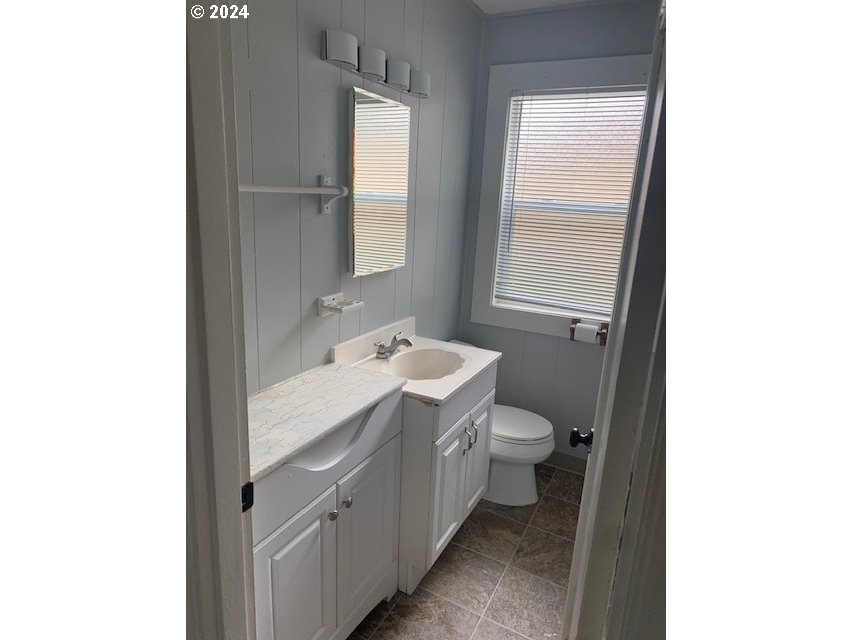 8445 Southeast Washington Street Portland, OR 97216 - Photo 15 of 17 a bathroom with a toilet sink and mirror