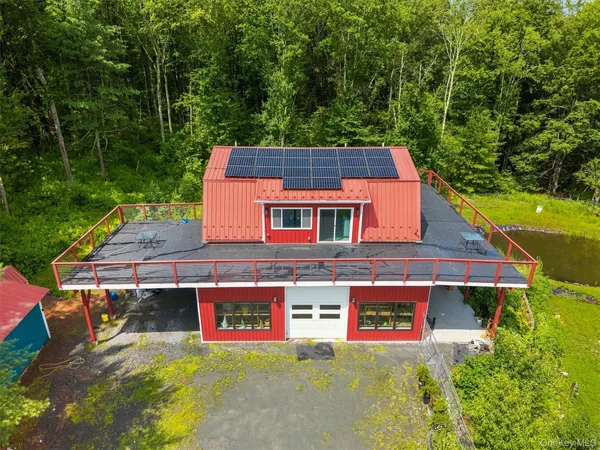an aerial view of a house with swimming pool and garden
