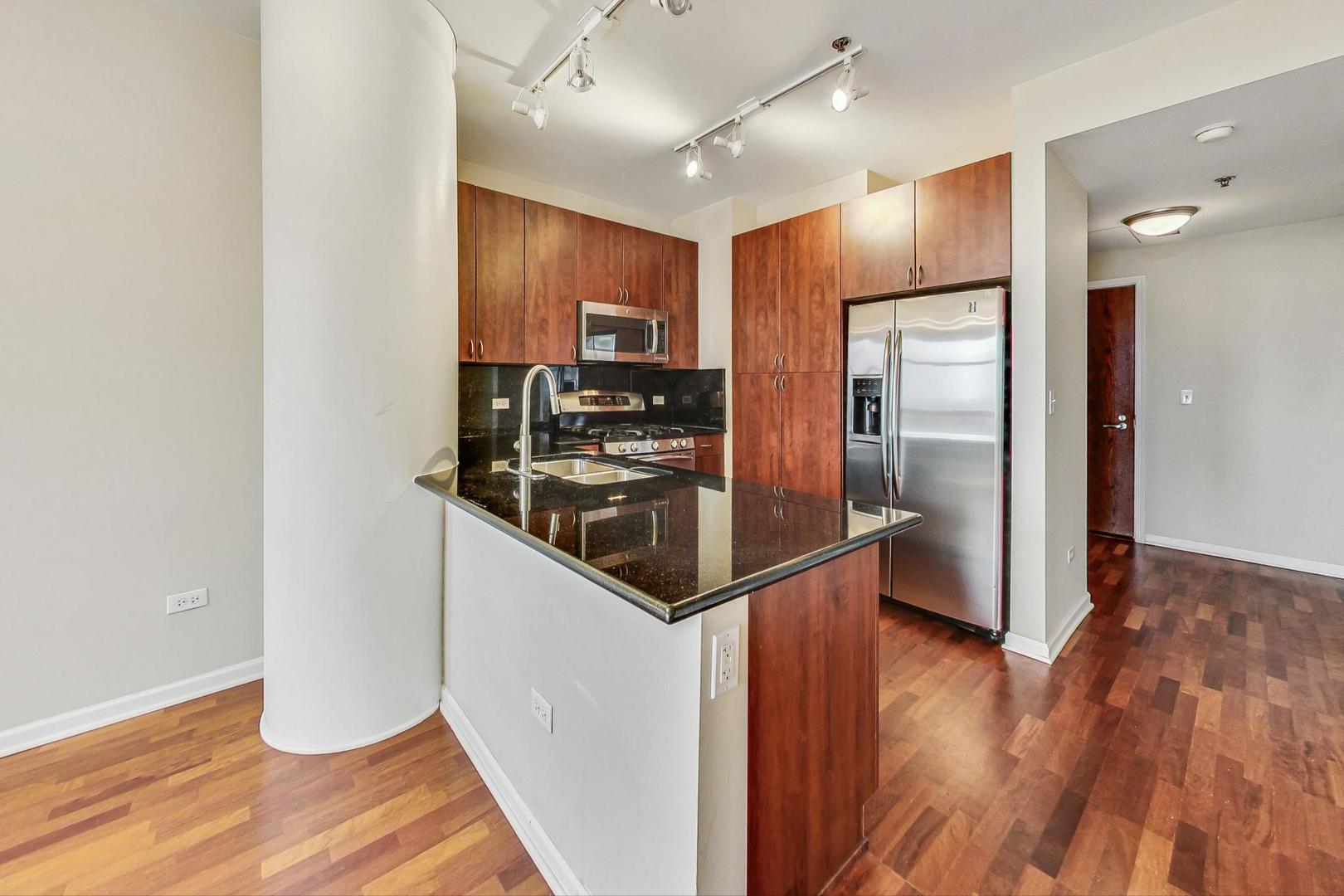 1255 South State Street, Unit 1918 Chicago, IL 60605 - Photo 4 of 16 a kitchen with stainless steel appliances granite countertop a refrigerator a sink and a stove