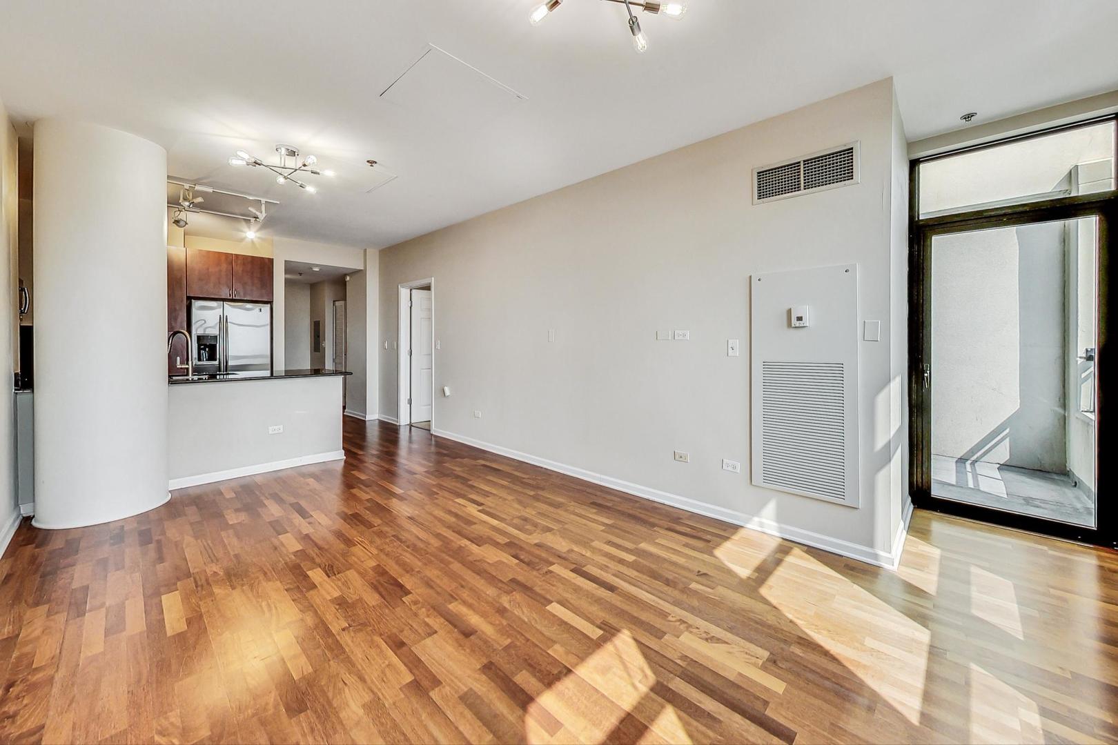 1255 South State Street, Unit 1918 Chicago, IL 60605 - Photo 5 of 16 a view of an empty room with window and wooden floor