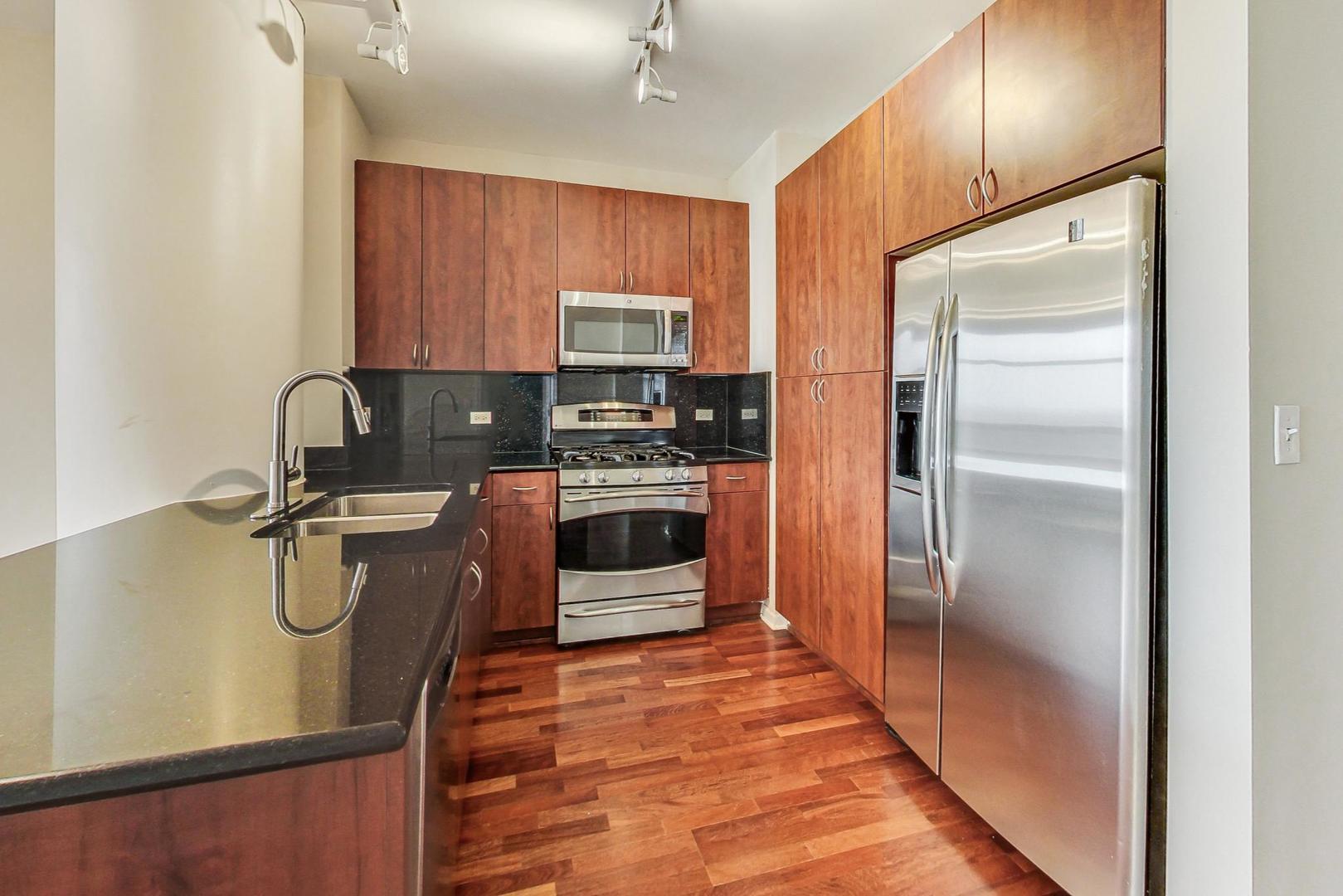 1255 South State Street, Unit 1918 Chicago, IL 60605 - Photo 6 of 16 a kitchen with stainless steel appliances granite countertop a refrigerator a stove a sink and a microwave