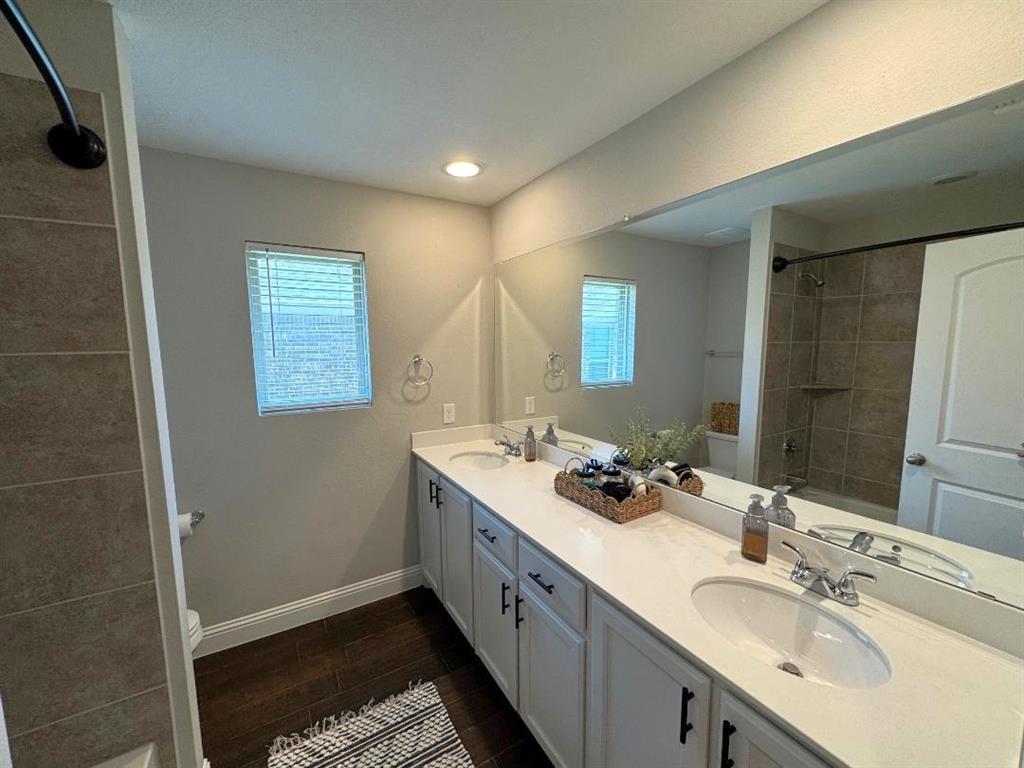 1455 Radecke Road Krum, TX 76249 - Photo 14 of 18 a bathroom with a double vanity sink and mirror