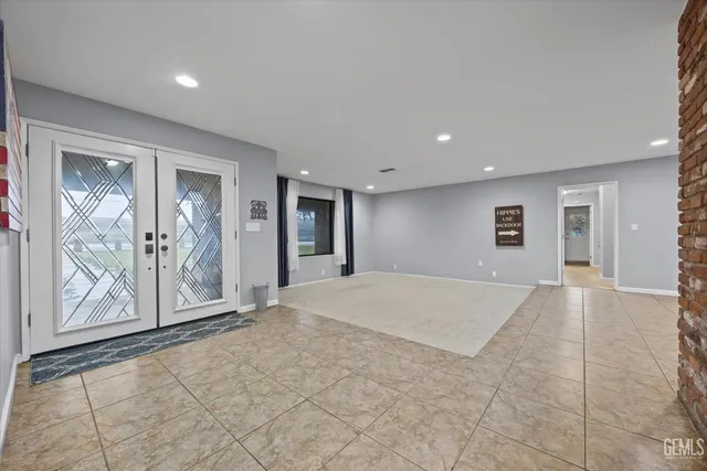 a large kitchen with stainless steel appliances granite countertop a large counter top a stove a sink and a refrigerator