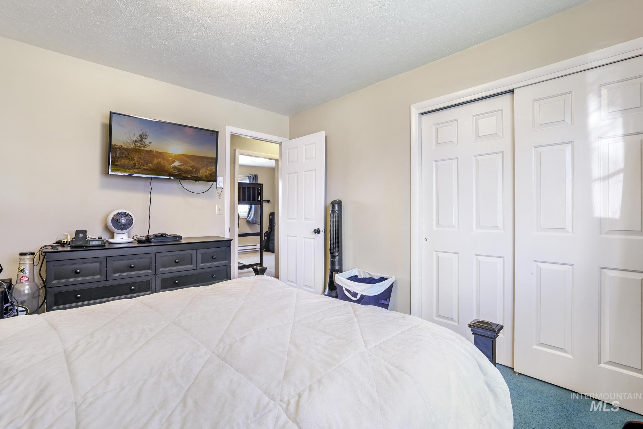 618 Sharon Street Rupert, ID 83350 - Photo 12 of 20 Bedroom featuring carpet floors, a closet, and a textured ceiling