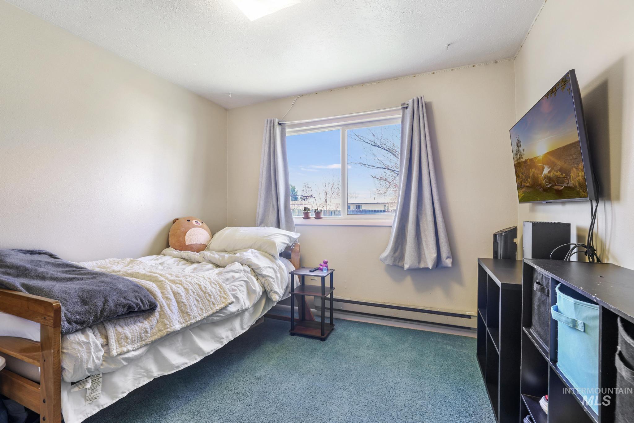 618 Sharon Street Rupert, ID 83350 - Photo 13 of 20 Bedroom featuring dark colored carpet and baseboard heating