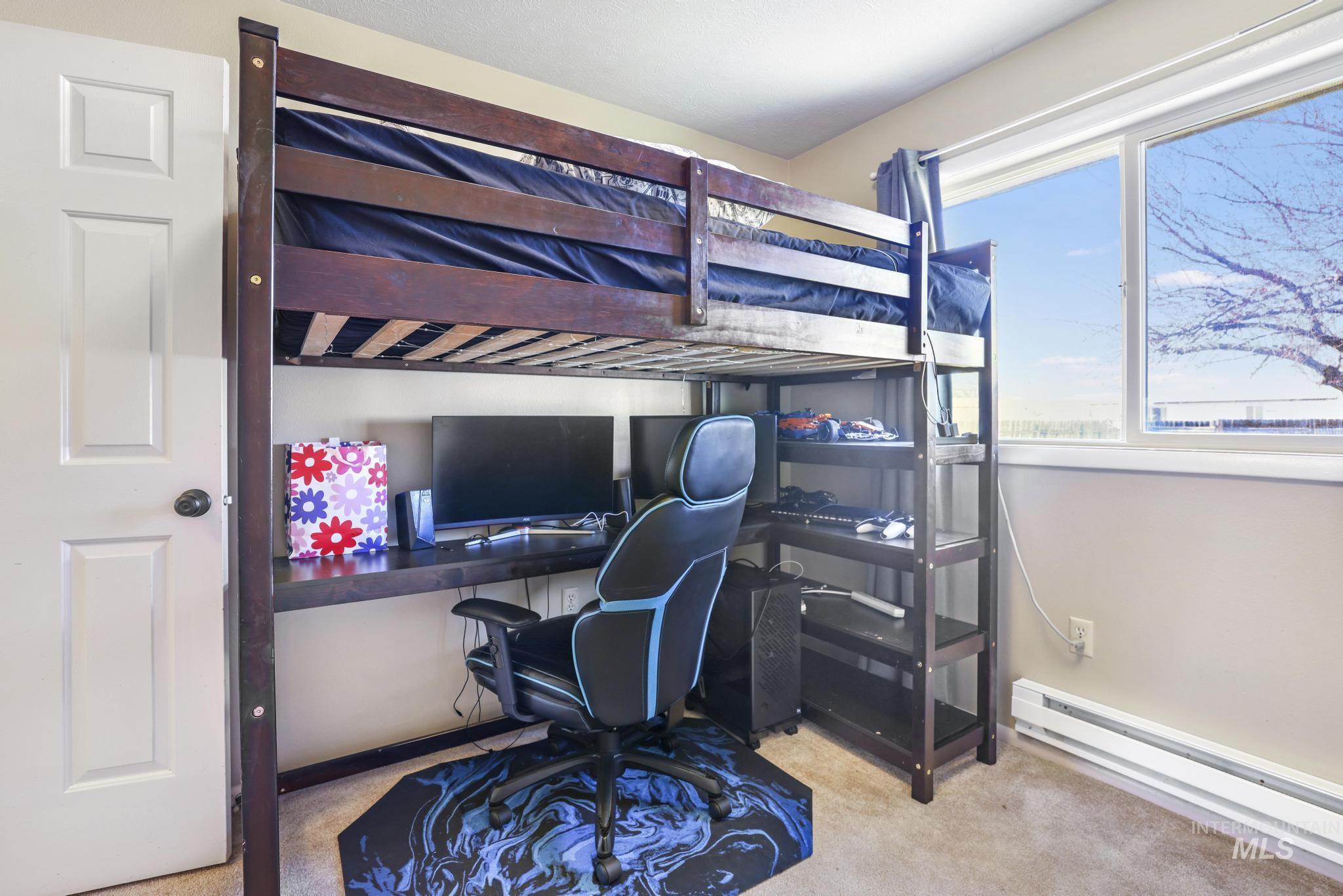 618 Sharon Street Rupert, ID 83350 - Photo 15 of 20 Bedroom with baseboard heating, light colored carpet, and built in desk