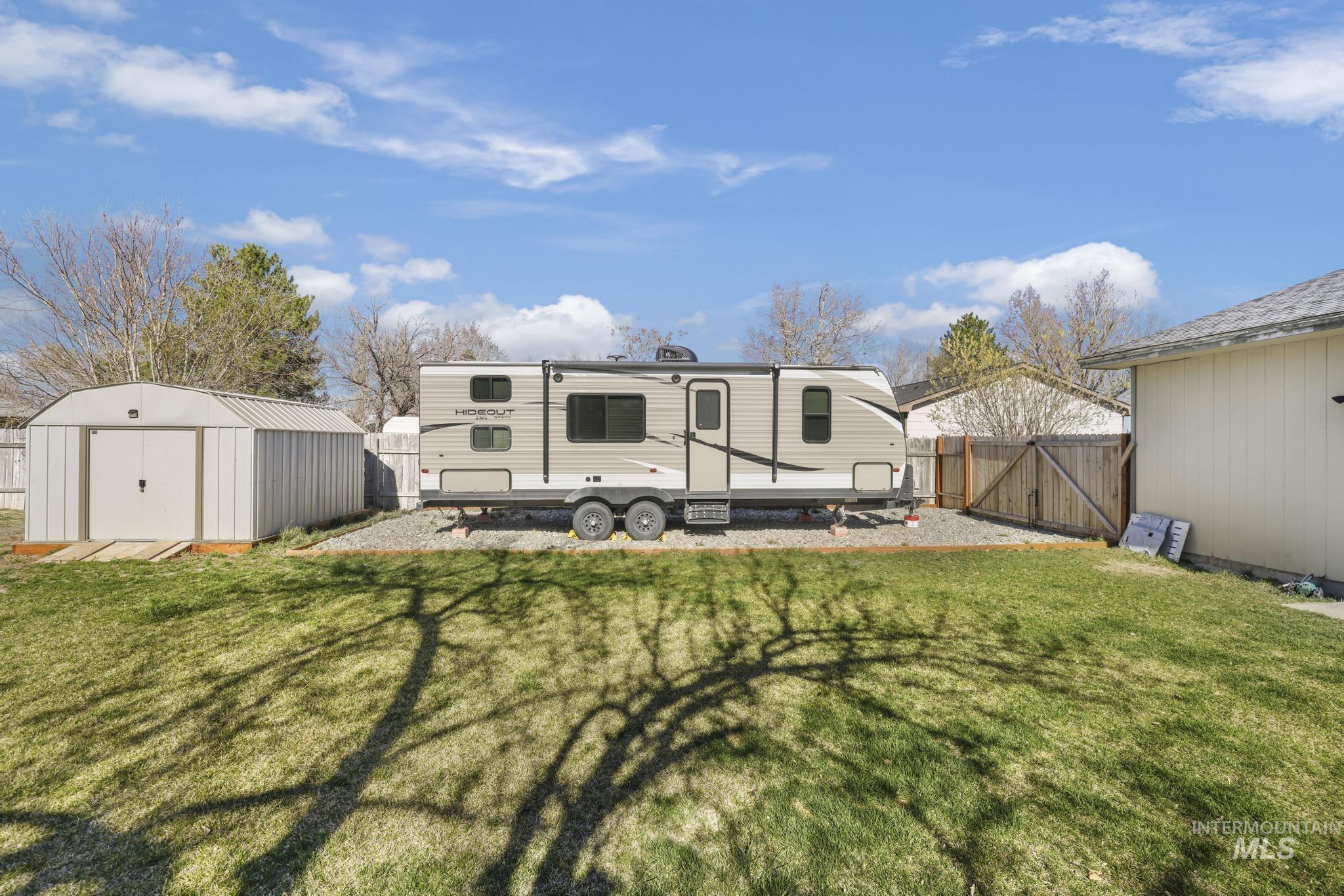 618 Sharon Street Rupert, ID 83350 - Photo 19 of 20 Rear view of house featuring a gate, a fenced backyard, and a storage unit