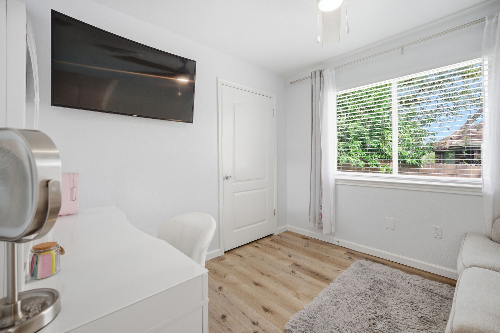 9024 Heiden Lane Austin, TX 78749 - Photo 14 of 28 Bright room with wood-finish flooring, a white paneled door, and a large window with white blinds