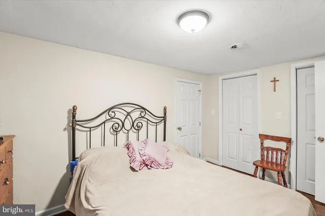 a bedroom with a bed and a dresser with mirror