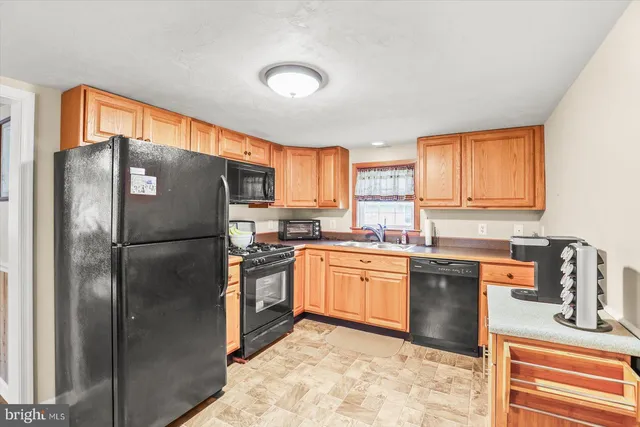 a kitchen with stainless steel appliances granite countertop a refrigerator stove top oven a sink and dishwasher