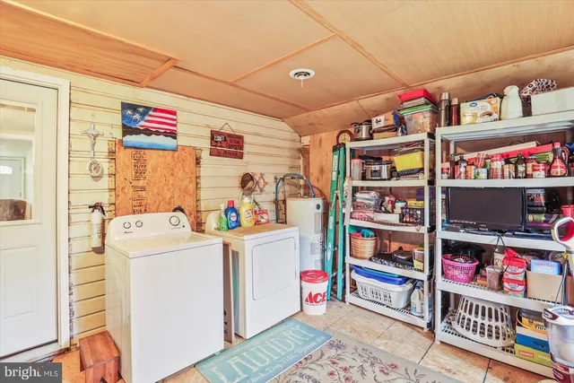 a utility room with fridge and closet