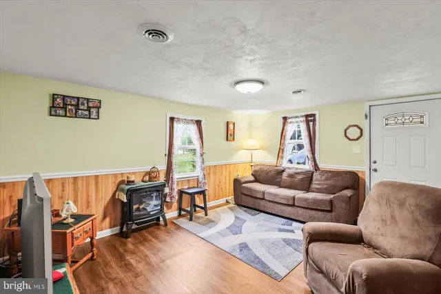 a living room with furniture a flat screen tv and a window