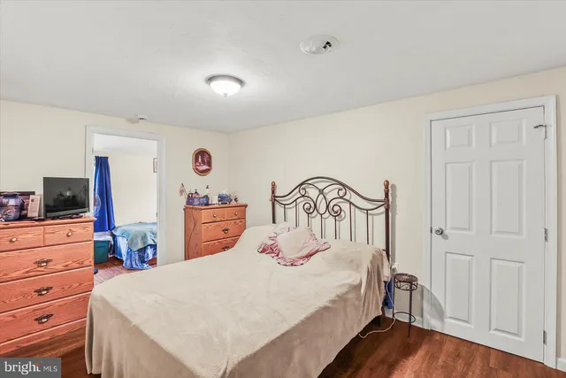 a bedroom with a bed and a flat tv screen on dresser