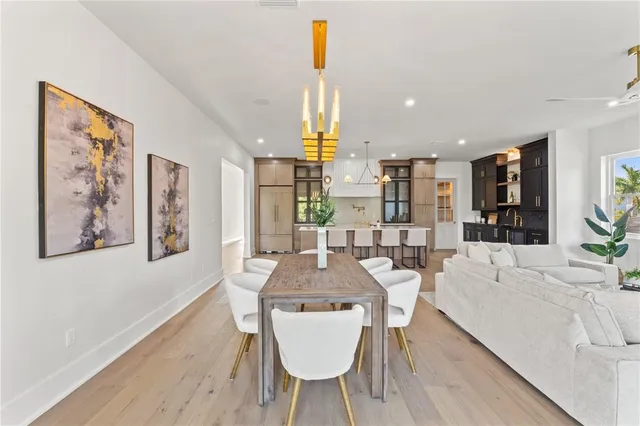 a view of a hallway with wooden floor and a bathroom