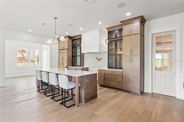 a large room with kitchen island a sink a window and white stainless steel appliances