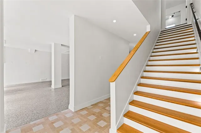 a view of a bedroom with wooden floor and a window