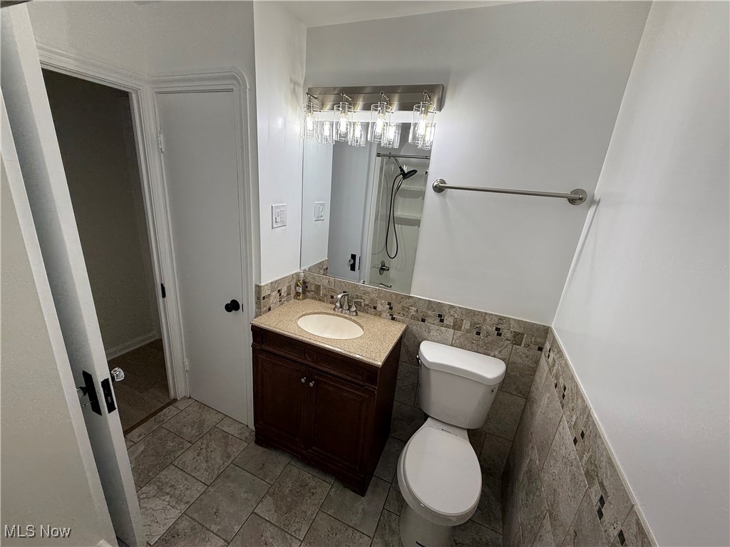 6475 Broadview Road Independence, OH 44131 - Photo 17 of 29 Bathroom featuring vanity, tile walls, and a shower