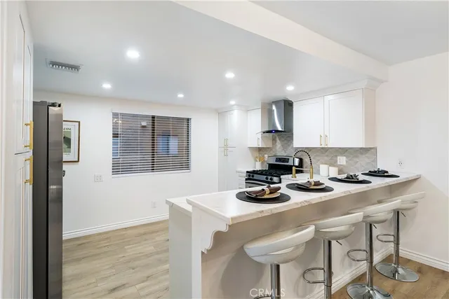 a kitchen with a table chairs stove and cabinets