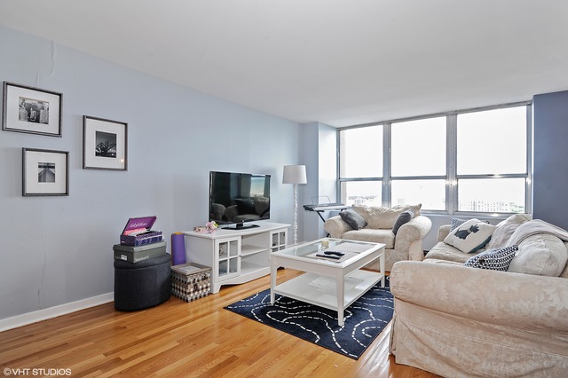 655 West Irving Park Road, Unit 3506 Chicago, IL 60613 - Photo 2 of 9 a living room with furniture and a flat screen tv