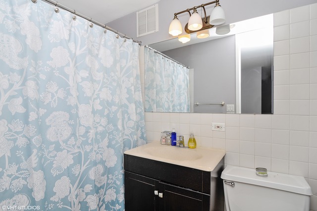 655 West Irving Park Road, Unit 3506 Chicago, IL 60613 - Photo 8 of 9 a bathroom with a sink vanity and a mirror