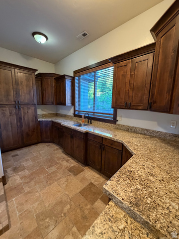 4536 North 475 East Provo, UT 84604 - Photo 35 of 65 U-shaped kitchen featuring dark wood cabinetry, light speckled countertops, and a stainless steel sink with a dark faucet
