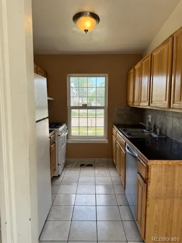 a kitchen with a sink a stove cabinets and a window