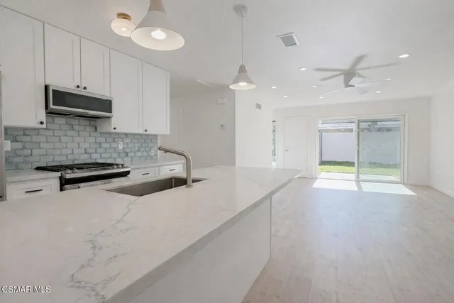 a kitchen with stainless steel appliances granite countertop a sink a stove and a refrigerator