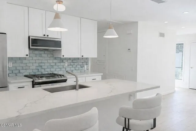 a kitchen with stainless steel appliances a sink a stove and a refrigerator