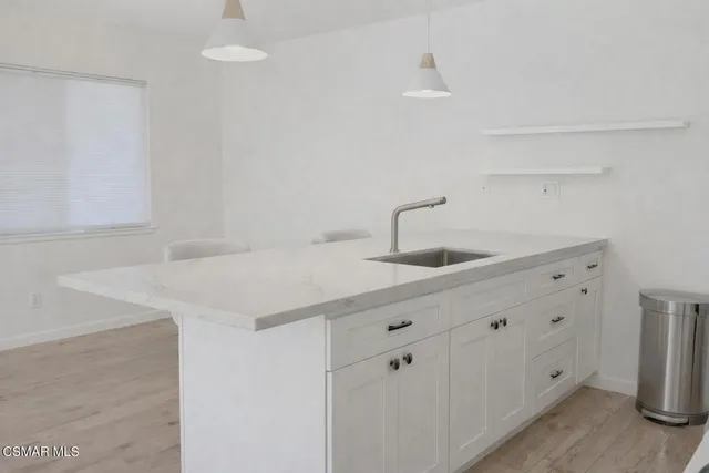 a view of wooden floor and a chandelier fan in a room