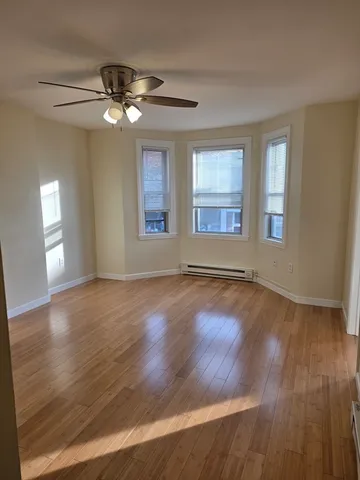 a view of a livingroom with wooden floor and a ceiling fan