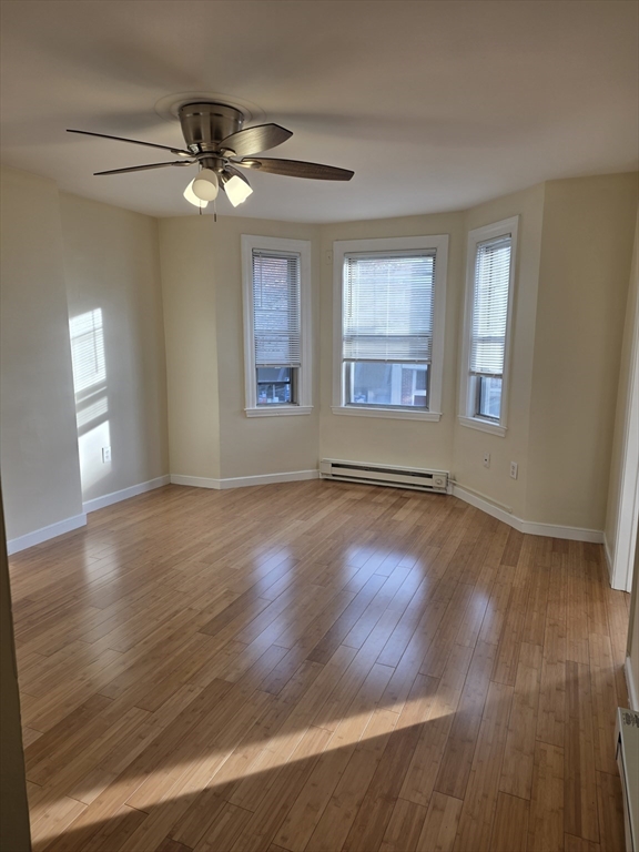 531 Cambridge Street, Unit 2 Cambridge, MA 02141 - Photo 3 of 22 a view of an empty room with wooden floor and a window