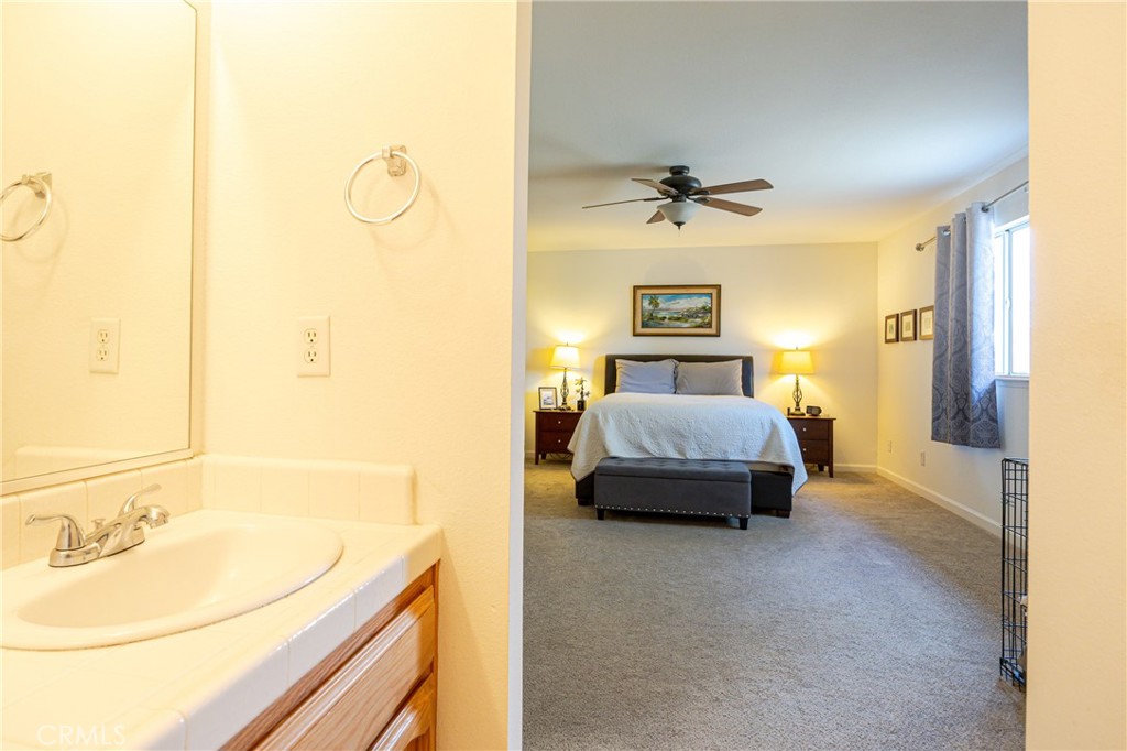 30142 Revis Road Coarsegold, CA 93614 - Photo 25 of 43 a spacious bedroom with a bed and ceiling fan