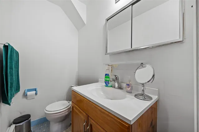 a bathroom with a sink toilet and a mirror