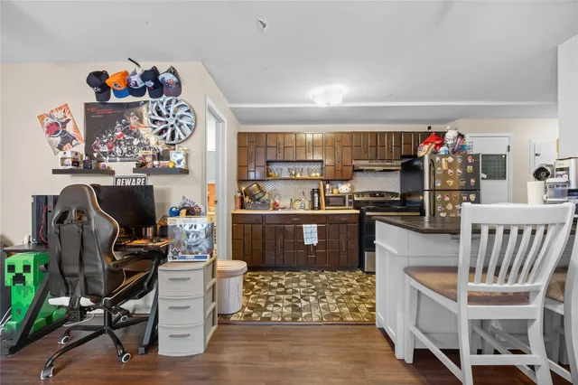a kitchen with stainless steel appliances kitchen island granite countertop a table and chairs in it