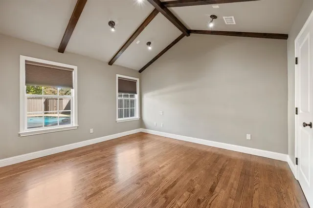 a view of an empty room with wooden floor