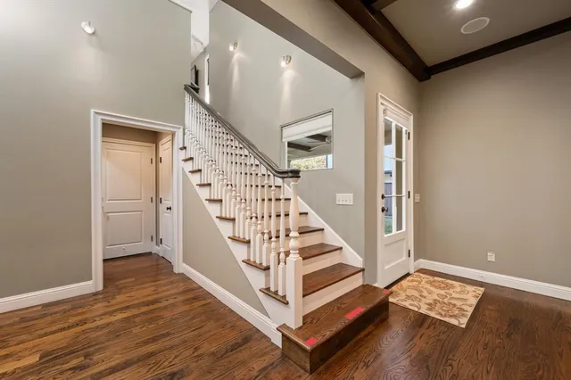a view of an empty room with wooden floor and a glass door